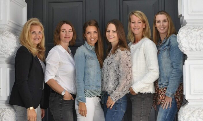 Teamfoto NDR Media und ndrb © NDR Media Fotografie von sechs Frauen vor einer Tür.