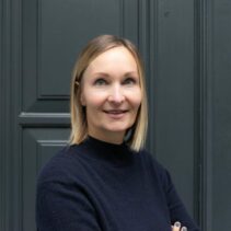 Susanne Görres Portraitfotografie vor grauer NDR Media Eingangstür.